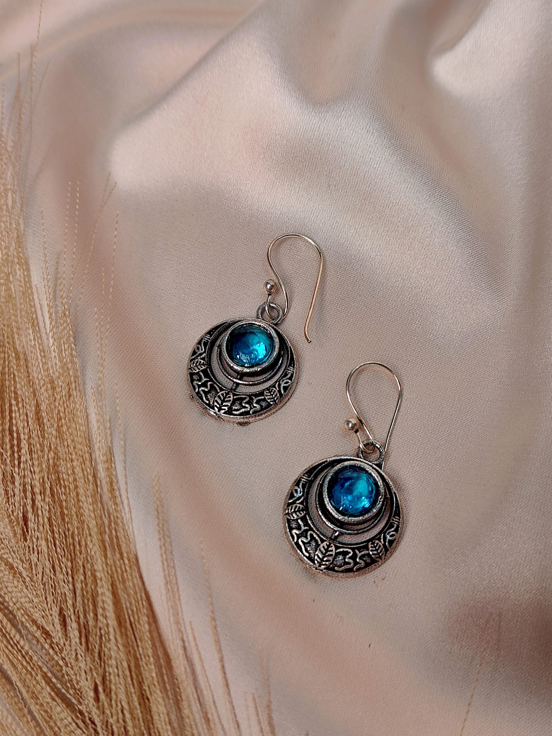 Nakkashi blue oxidised circular earrings with engraved detailing and central stone